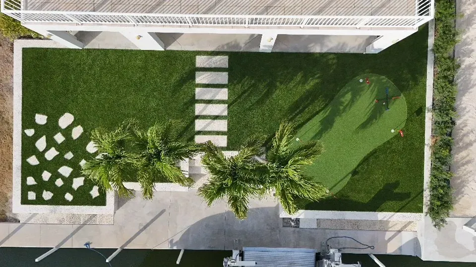 After: turf, putting green, paver path and tropical planting